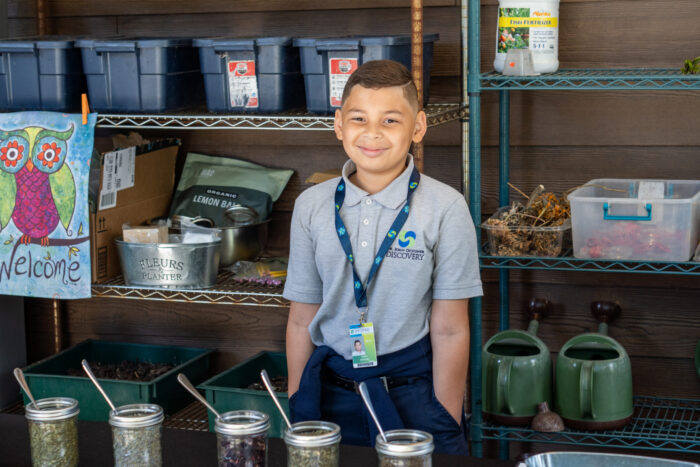 Student smiling and learning in an outdoor classroom.