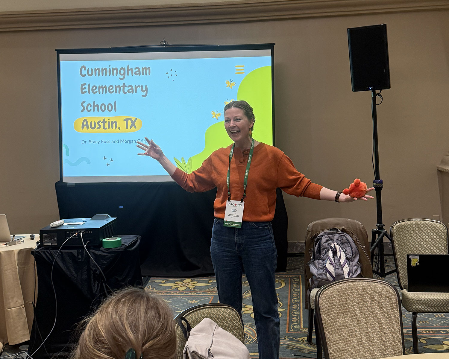 Presenter standing in front of a projection screen reading “Cunningham Elementary School, Austin, TX,” speaking to an audience during a conference session.